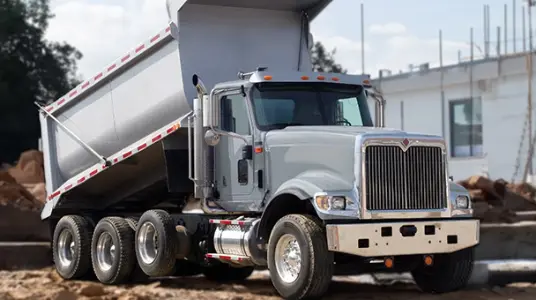 A sturdy dump truck parked on a construction site, showcasing the reliability and versatility of financing options for heavy-duty vehicles used in construction projects.